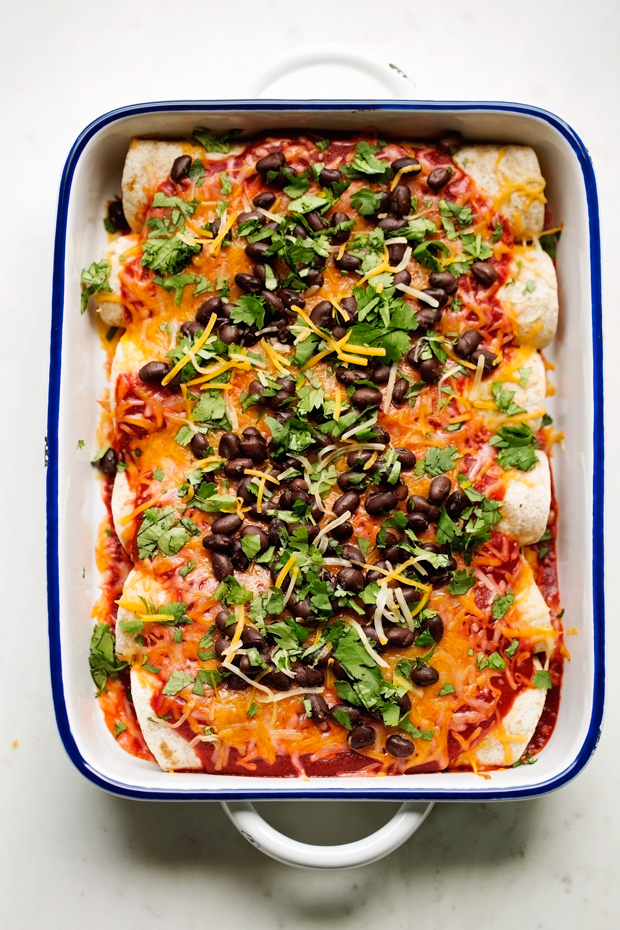 Breakfast enchiladas loaded with shredded potatoes, scrambled eggs, and black beans drizzled with my homemade ranchero sauce and shredded cheese -- comfort food to the max! #breakfast #breakfastenchiladas #enchiladas #rancherosauce | Littlespicejar.com