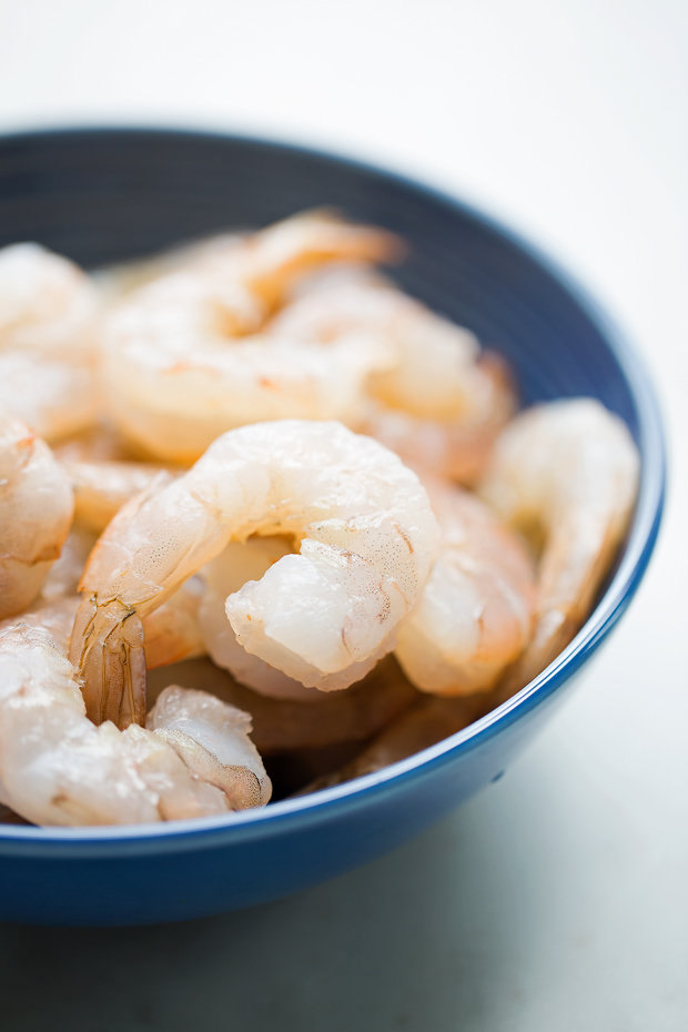 cleaned shrimp in a blue bowl on white marble