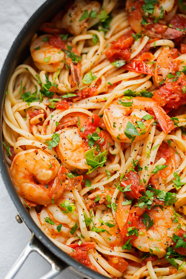 spicy shrimp pasta in saute pan tipped with fresh parsley