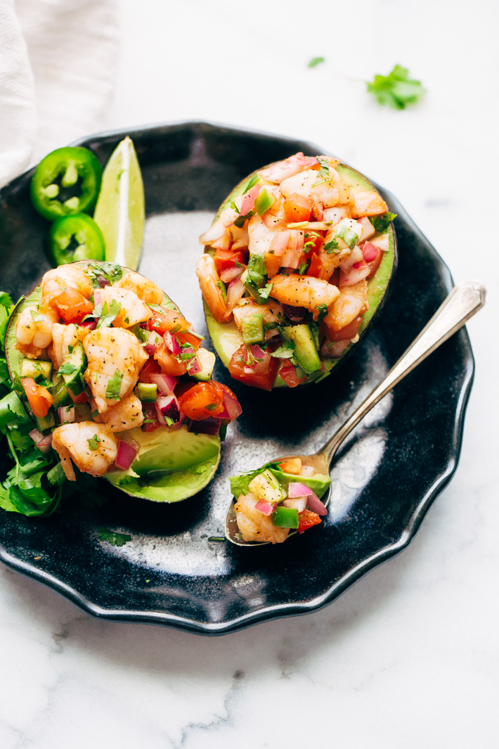 Mexican Shrimp Cocktail Stuffed Avocados - these avocados boats are easy to make and contain just 7 grams of next carbs! A fresh summer meal that will keep you nice and full! #avocadoboats #stuffedavocados #shrimpceviche #lowcarbmeals | Littlespicejar.com