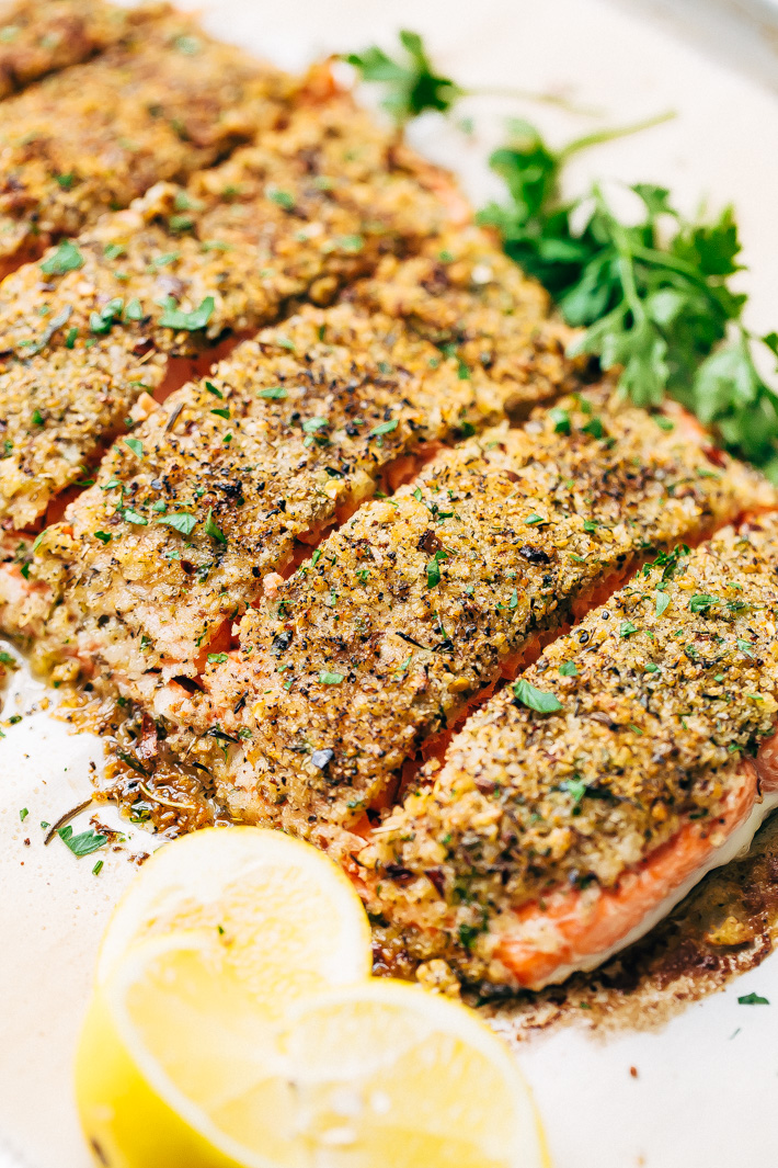 panko crusted lemon pepper salmon on parchment with lemon wedges