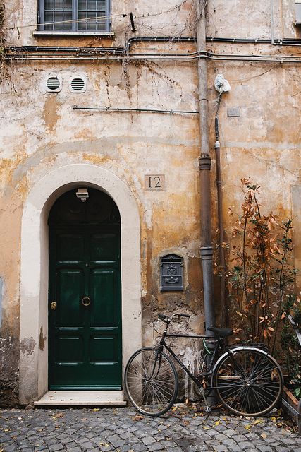 image of green door in Italy with a bike leaning against the wall