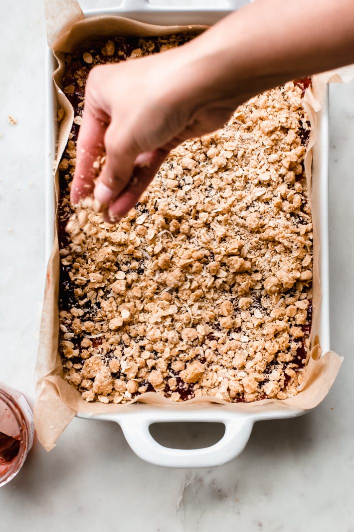 Peanut Butter and Jelly Oat Bars - A tender and buttery peanut butter laced oat crust, topped with your favorite jam and peanut butter and oat crumble. So yummy and so easy to prep! #crumblebars #peanutbutterbars #bars #oatmealbars #peanutbutterjelly #oatbars #oatcrumblebars | Littlespicejar.com