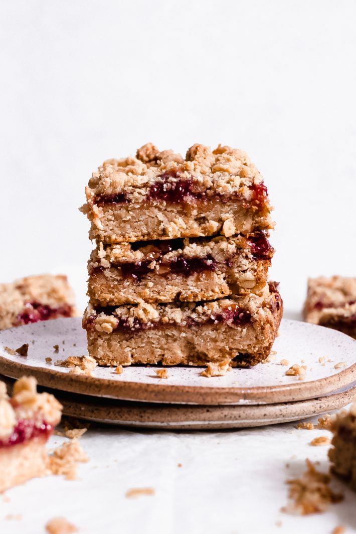 Peanut Butter and Jelly Oat Bars - A tender and buttery peanut butter laced oat crust, topped with your favorite jam and peanut butter and oat crumble. So yummy and so easy to prep! #crumblebars #peanutbutterbars #bars #oatmealbars #peanutbutterjelly #oatbars #oatcrumblebars | Littlespicejar.com