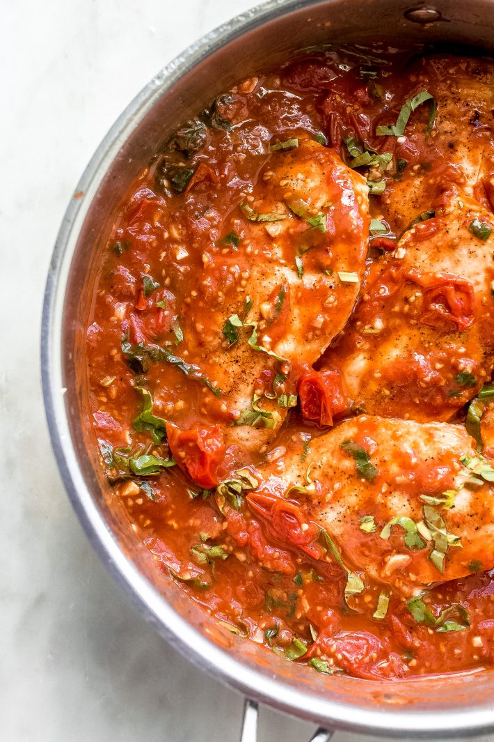 Saucy Burst Tomato Basil Chicken - Learn how to make a simple one pot tomato basil chicken recipe. This recipe requires simple ingredients and tastes great over pasta, rice, cauli-rice, or with crusty bread! #chickendinner #chickenrecipes #easychickenrecipes #tomatobasilchicken #tomatobasilsauce | Littlespicejar.com