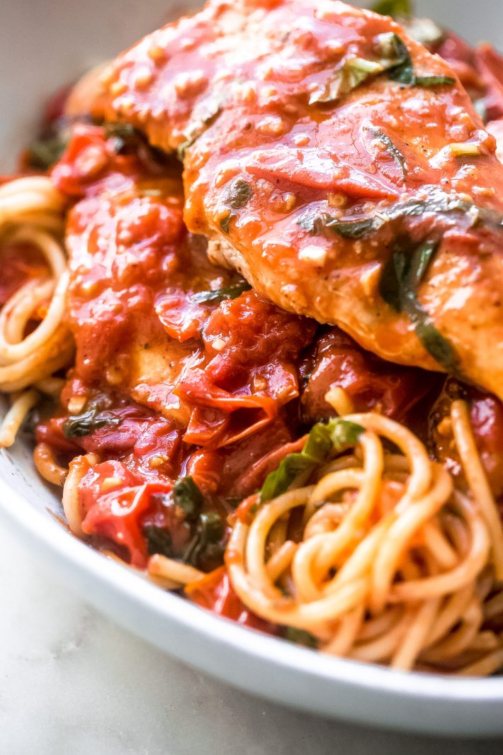 Saucy Burst Tomato Basil Chicken - Learn how to make a simple one pot tomato basil chicken recipe. This recipe requires simple ingredients and tastes great over pasta, rice, cauli-rice, or with crusty bread! #chickendinner #chickenrecipes #easychickenrecipes #tomatobasilchicken #tomatobasilsauce | Littlespicejar.com