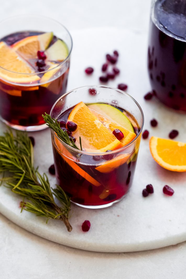 Festive Sangria Mocktail - Made with fresh fruit, juices, and a little fizz, this sangria cocktail is sure to be perfect for your holiday party! #sangriamocktail #mocktail #newyearsevecocktail #mocktails #sangria | Littlespicejar.com