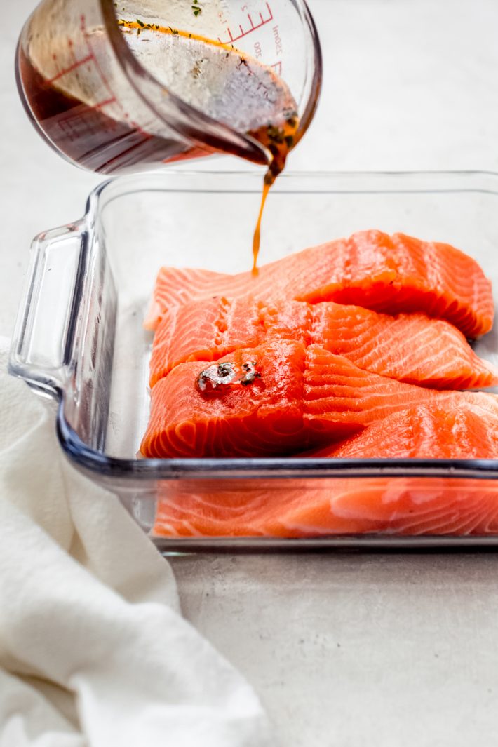 pouring marinade on salmon