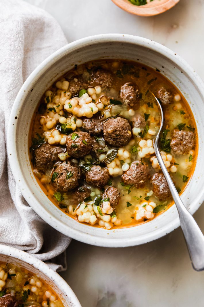 mini meatball couscous soup in speckled bowl