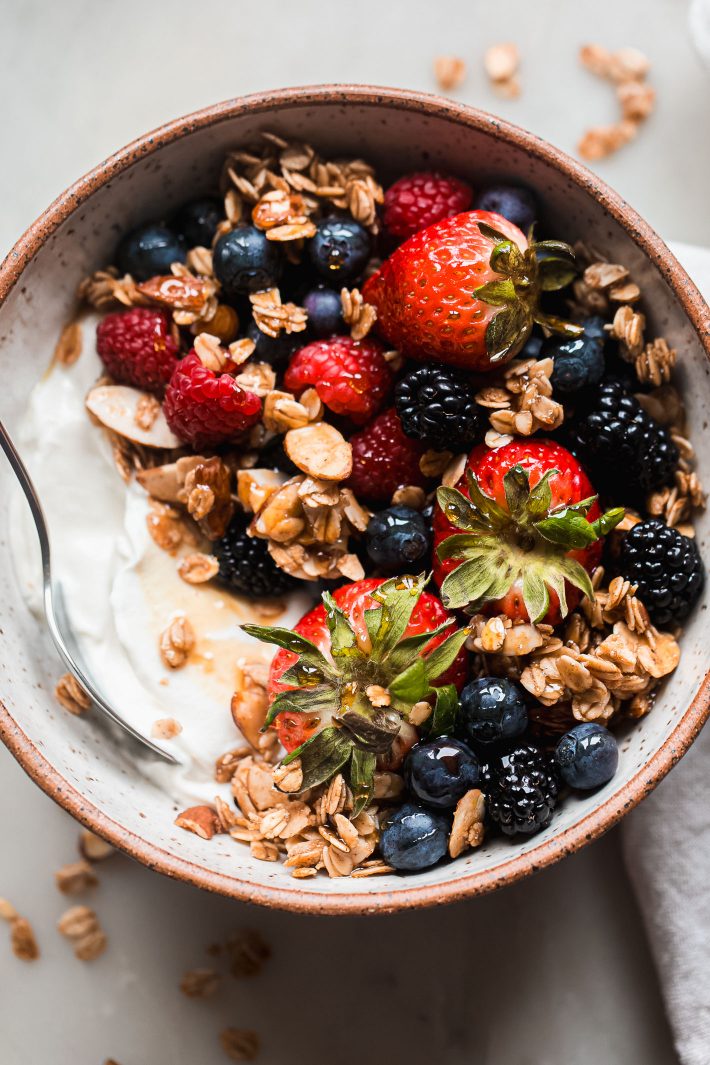 bowl with yogurt, honey almond granola, and fresh berries
