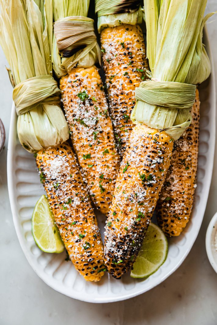 Mexican street corn on plate with lime wedges