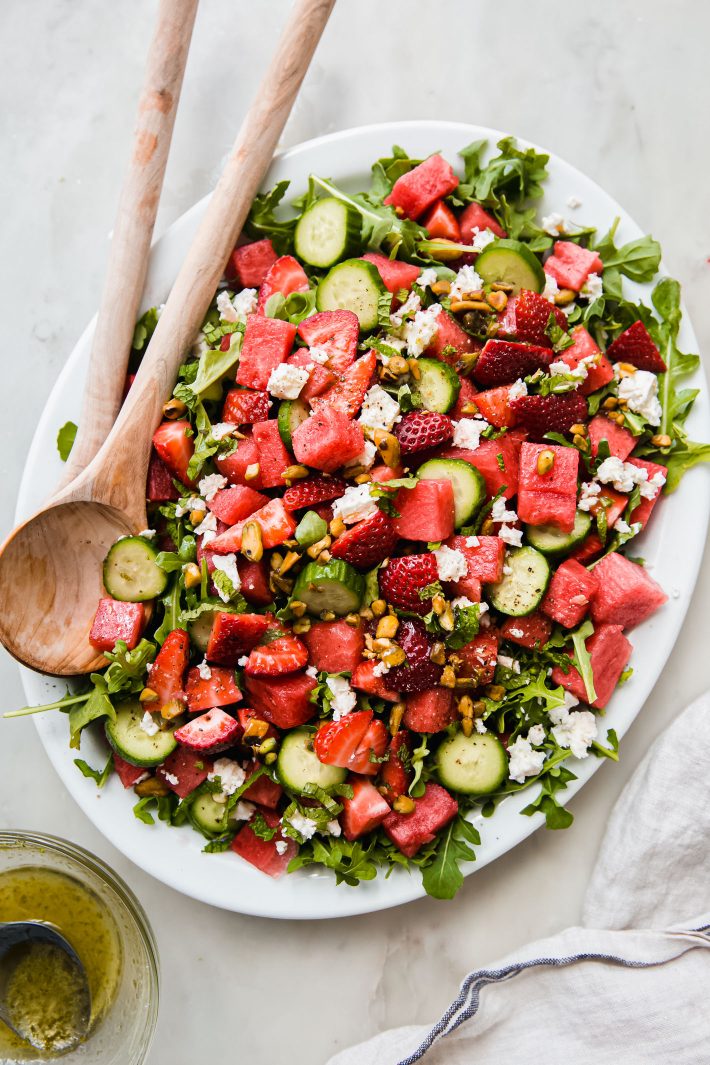 dressed watermelon salad in platter with spoons