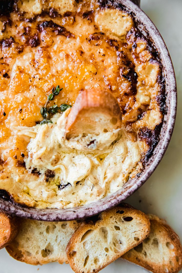 hot caramelized onion dip on marble with crostini