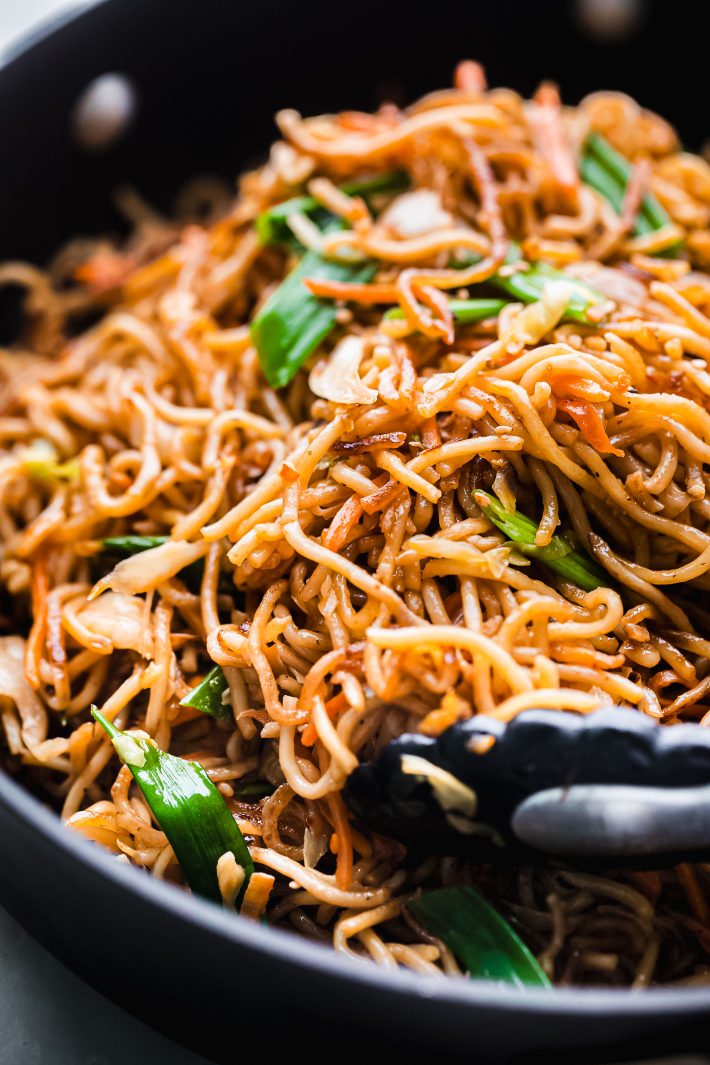 wok fried noodles in pan with tongs
