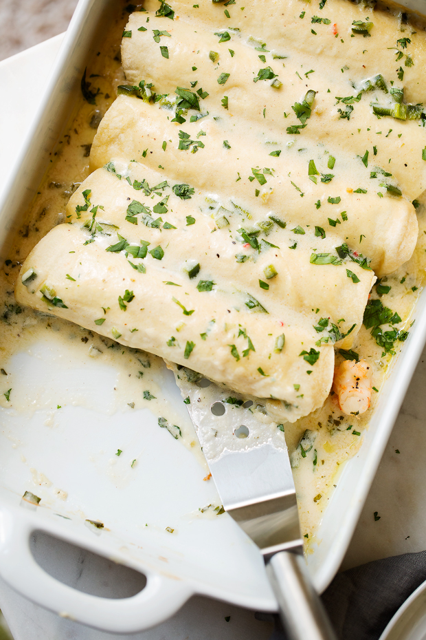 Shrimp Enchiladas with Creamy Poblano Sauce - Simple and delicious shrimp enchiladas stuffed with fresh baby spinach and matchstick carrots. Then drizzle with the creamiest cheese and poblano sauce! #shrimpenchiladas #enchiladas #seafoodenchiladas #mexicanfood | Littlespicejar.com @Littlespicejar