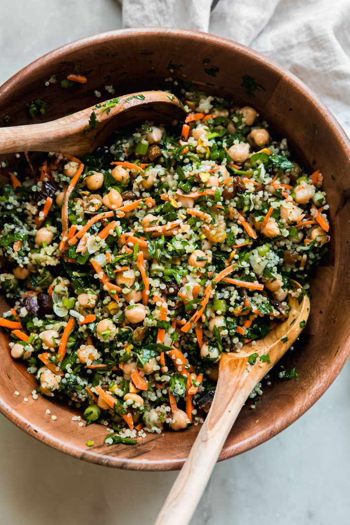 chickpea quinoa salad in wooden bowl with wooden serving spoons
