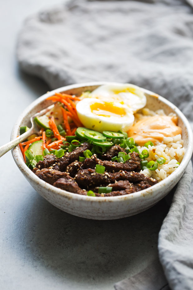Korean BBQ Bowls with Garlic Scented Rice - Warm, comforting bowls with marinated steak, garlic rice, and a pickled cucumber salad. It's seriously amazing! #koreanbbqbowls #bowls #garlicrice | Littlespicejar.com