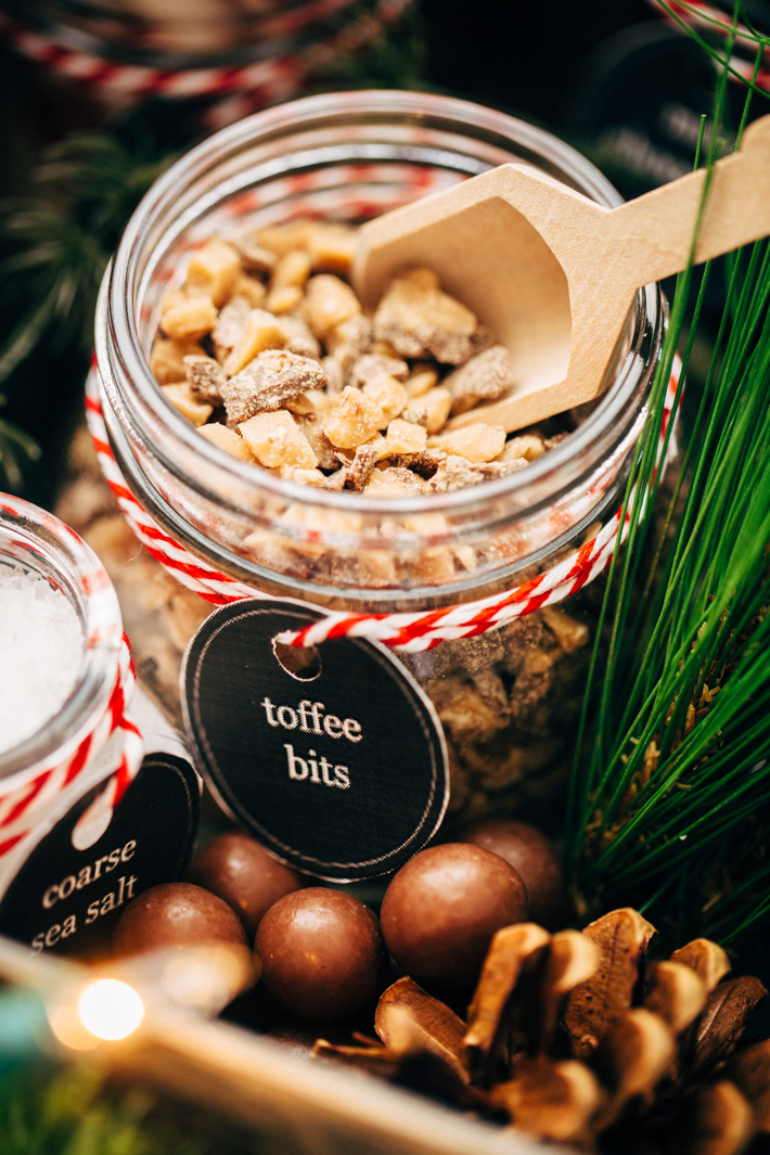 toffee bits in mason jar with label and wooden scoop