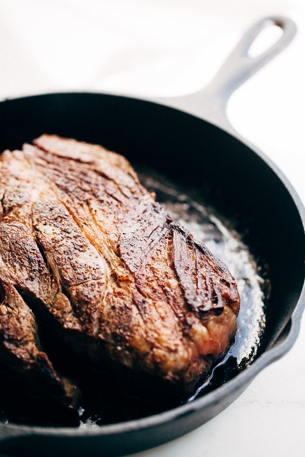 cast iron skillet with seared chuck roast 