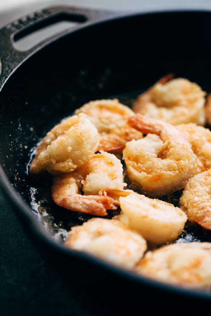 Lighter Honey Walnut Shrimp - A lighter take on the takeout classic! We're pan frying the shrimp in just a hint of oil, tossing it together with candied walnuts and a creamy sauce then serving it over a big mound of greens and rice! #honeywalnutshrimp #takeoutfakeout #walnutshrimp #shrimp | Littlespicejar.com