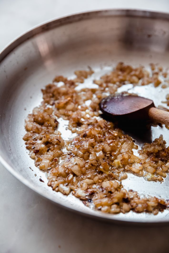 caramelized onions in skillet with wooden spoon