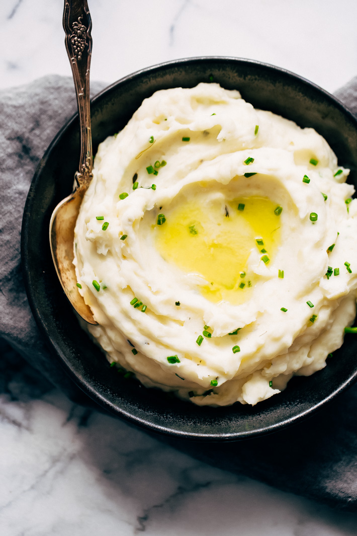 mashed potatoes with butter pool and chives in black plate