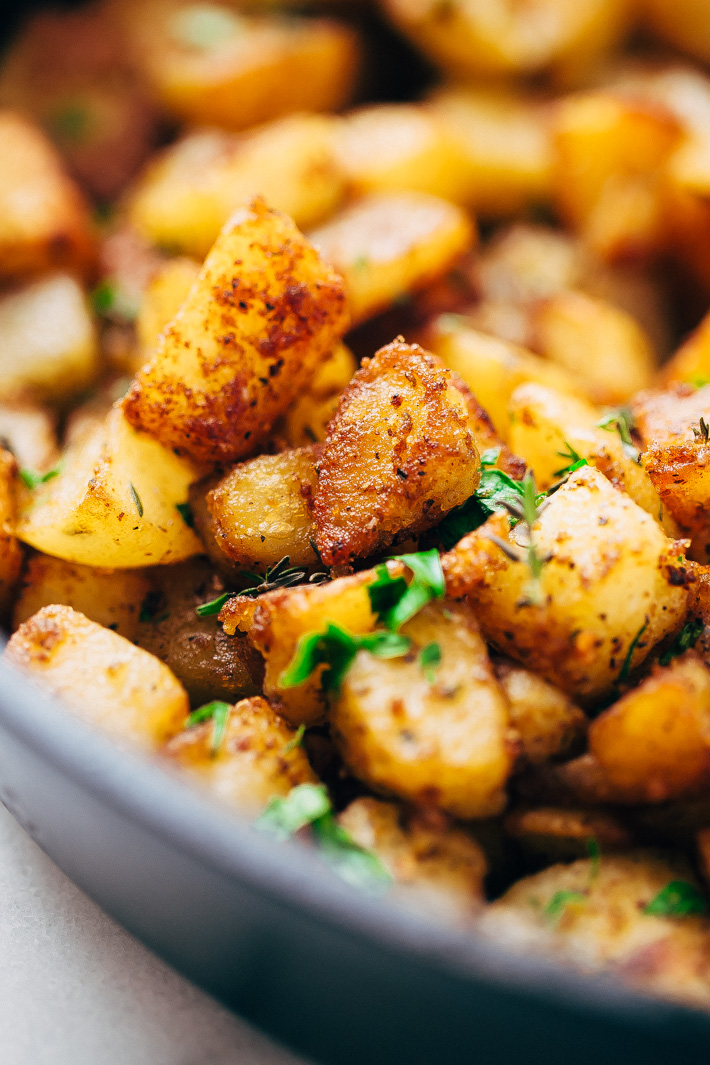 close up of crispy coated cubes of potatoes that are panfried in cast iron