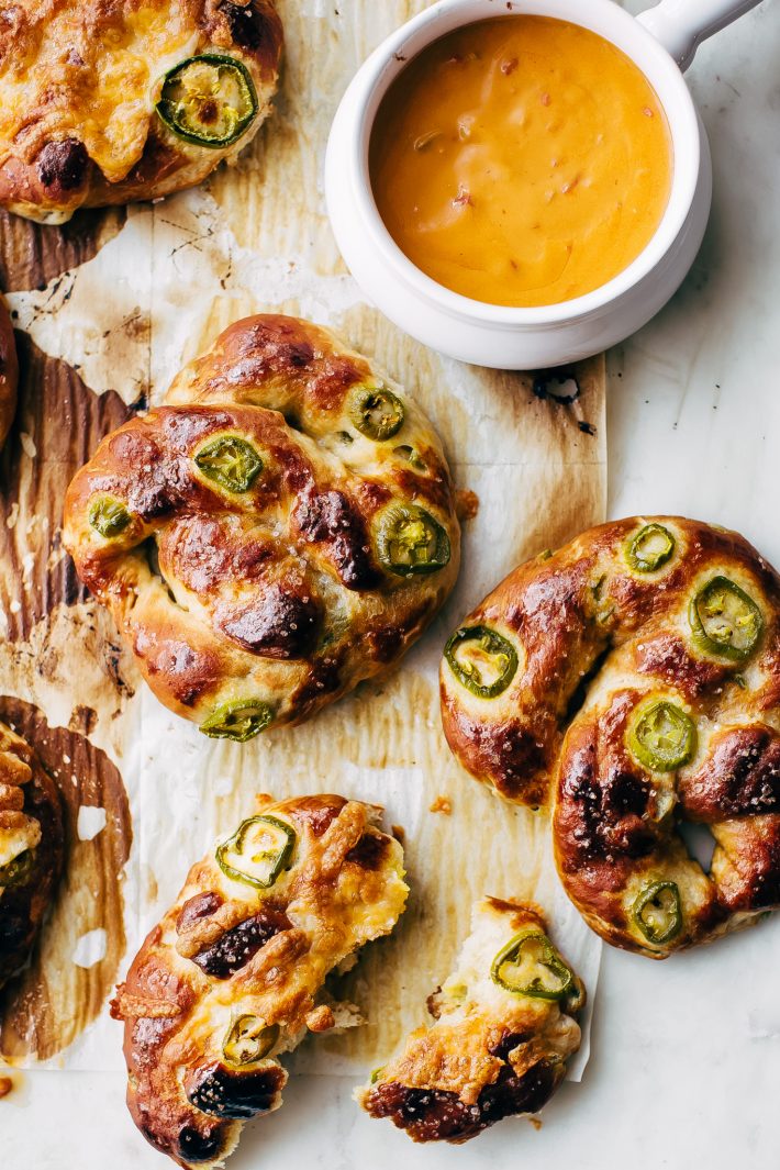 Cheddar Jalapeño Soft Pretzels - made with simple ingredients and loaded with tamed jalapeños and tons of cheddar cheese on top! So good you'll crave them ALL THE TIME! #softpretzels #jalapeñopretzels #jalapenosoftpretzels #softpretzelrecipe | Littlespicejar.com