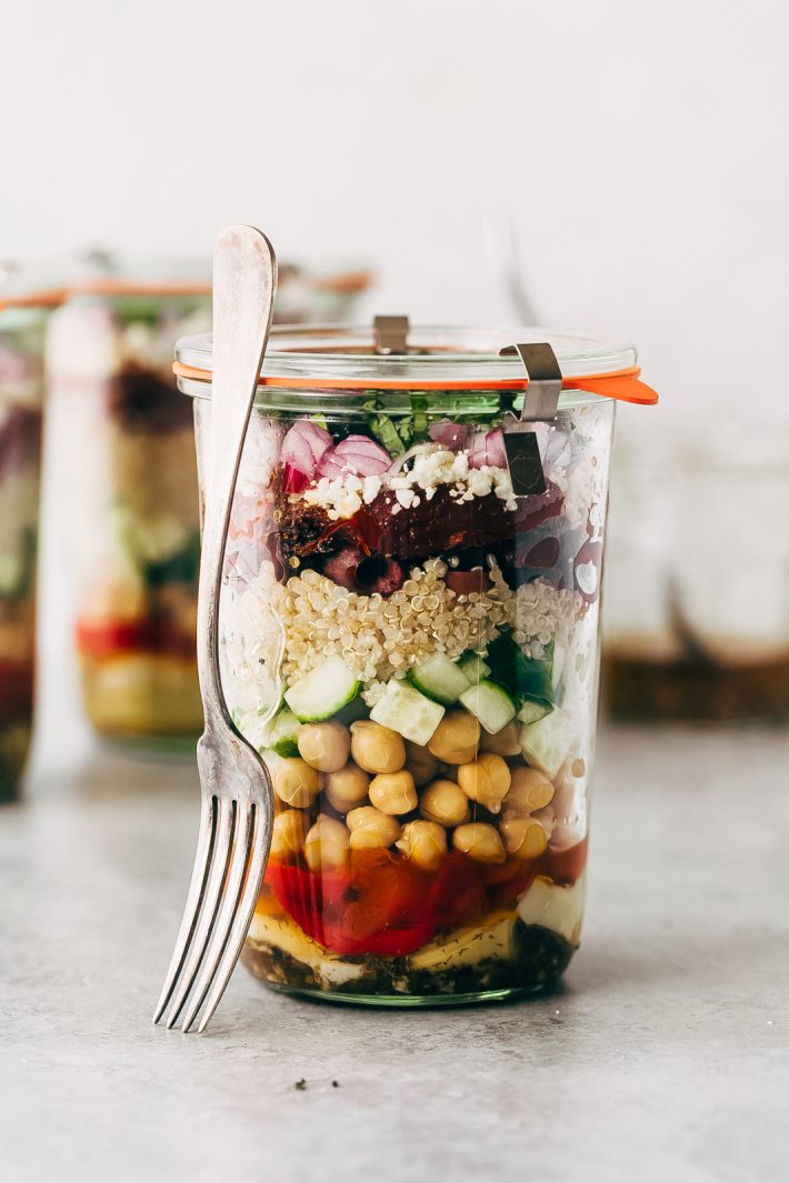 Greek Quinoa Salad Jars - these jars are prefect for meal prepping and popping them in the refrigerator for the week ahead. Swap the ingredients for ones you like, this is so customizable! #saladjars #greeksaladjars #quinoasaladjars | Littlespicejar.com