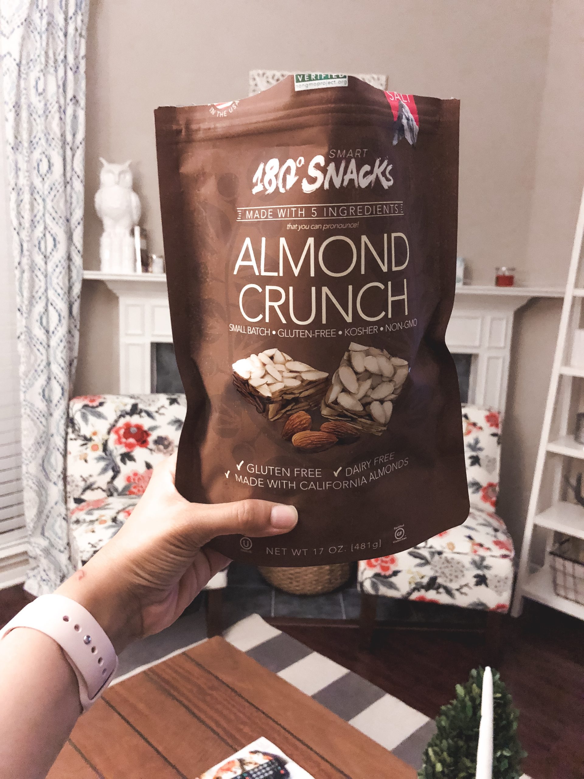 hand holding a package of snacks: almond crunch