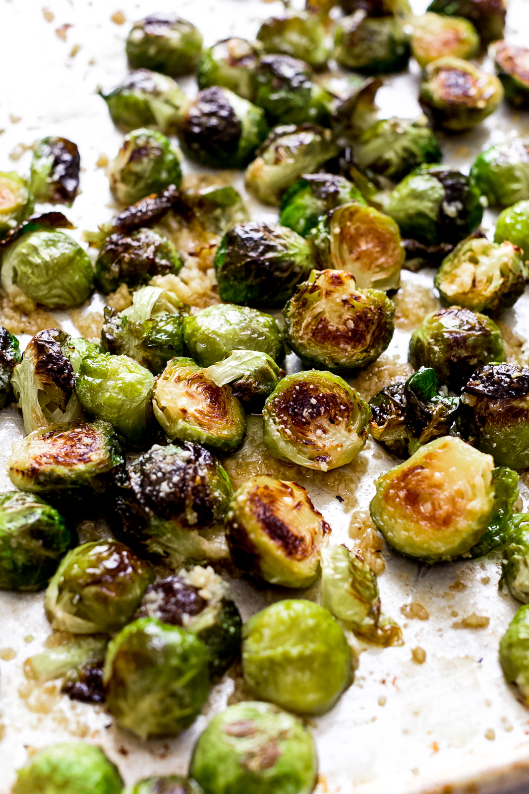 roasted Brussels sprouts on sheet pan doused in garlic butter and sprinkled with parmesan