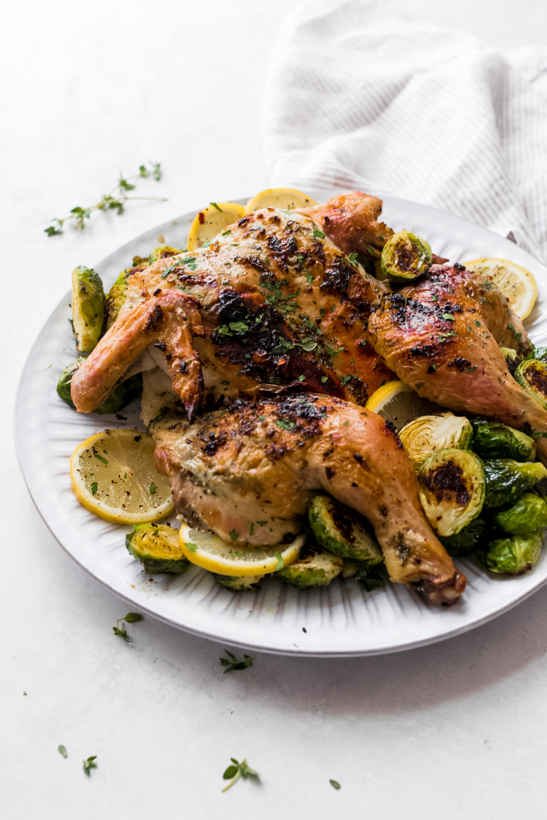 plate with prepared roasted chicken with lemon and Brussel sprouts on grey surface