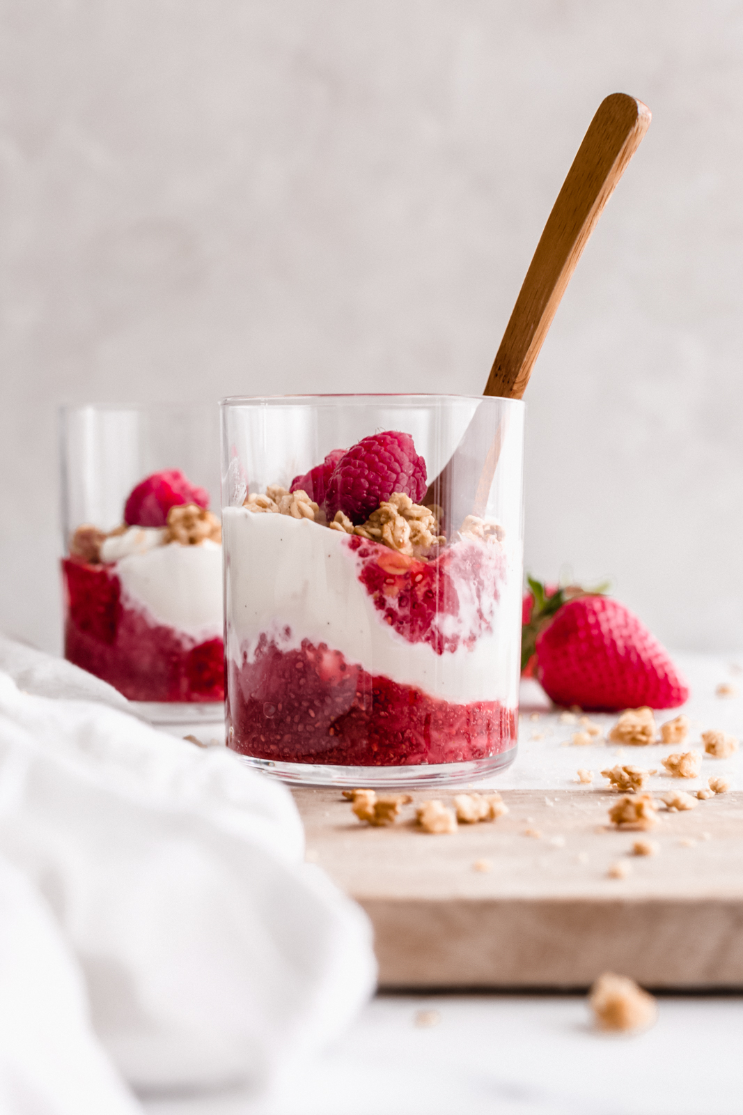 glass of yogurt parfait with chia jam, granola and fresh berries