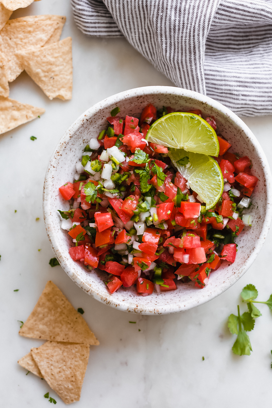 bowl with freshly made pico de gallo topped with lime wedges