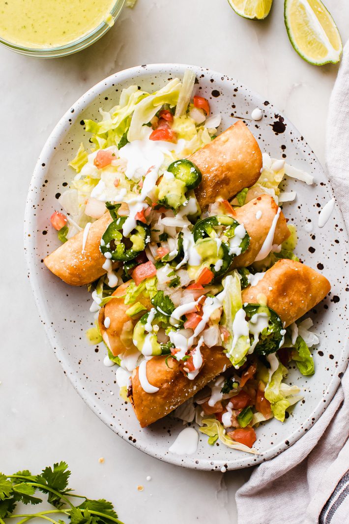 cheesy taquitos with sour cream and toppings