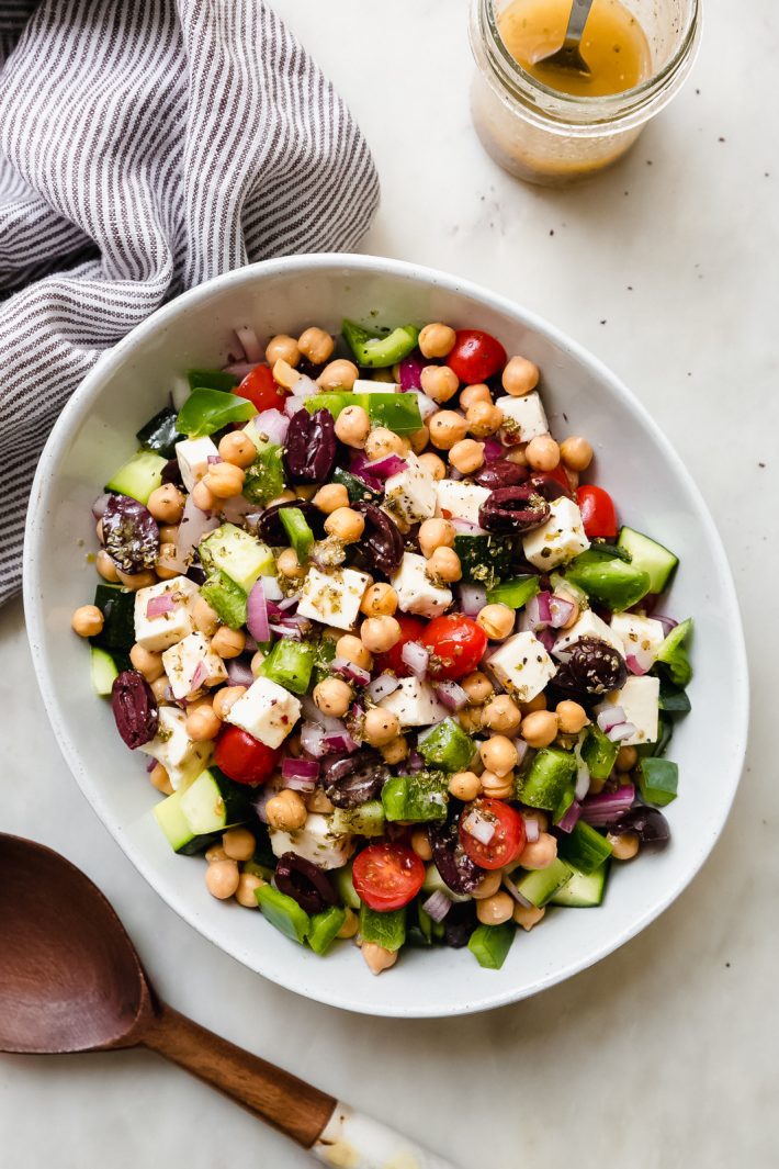 dressed and prepared Greek salad topped with marinated feta cheese 