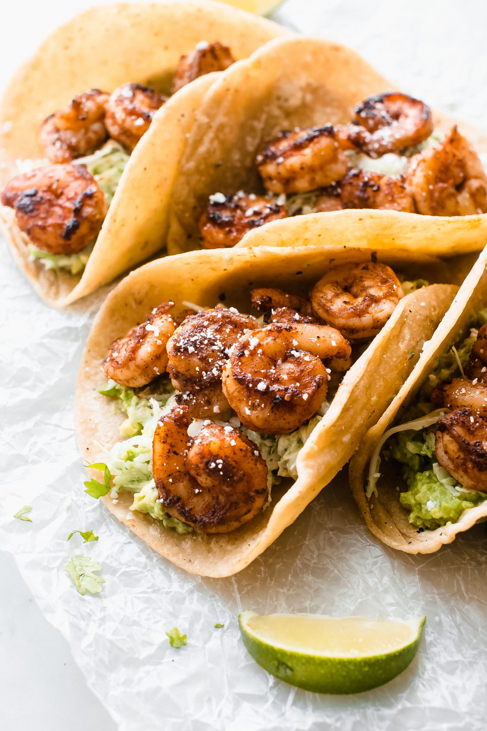 close up of blackened shrimp tacos on crinkled parchment paper