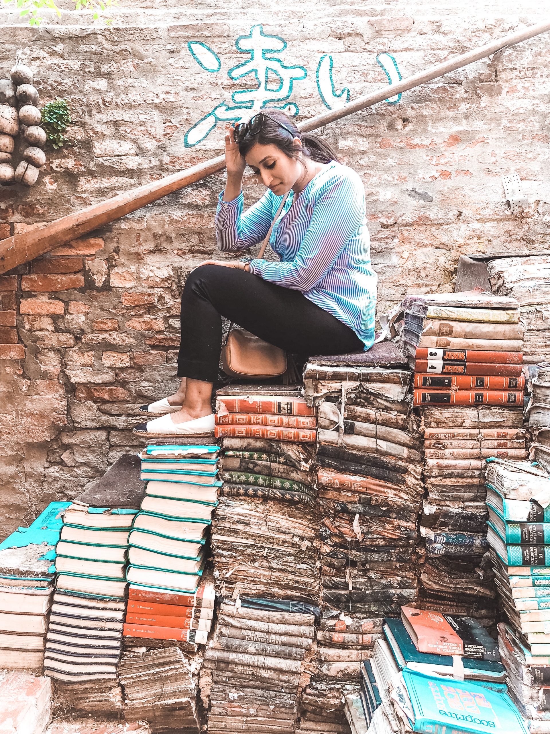 me sitting on a stairway of books in a bookstore on Venice