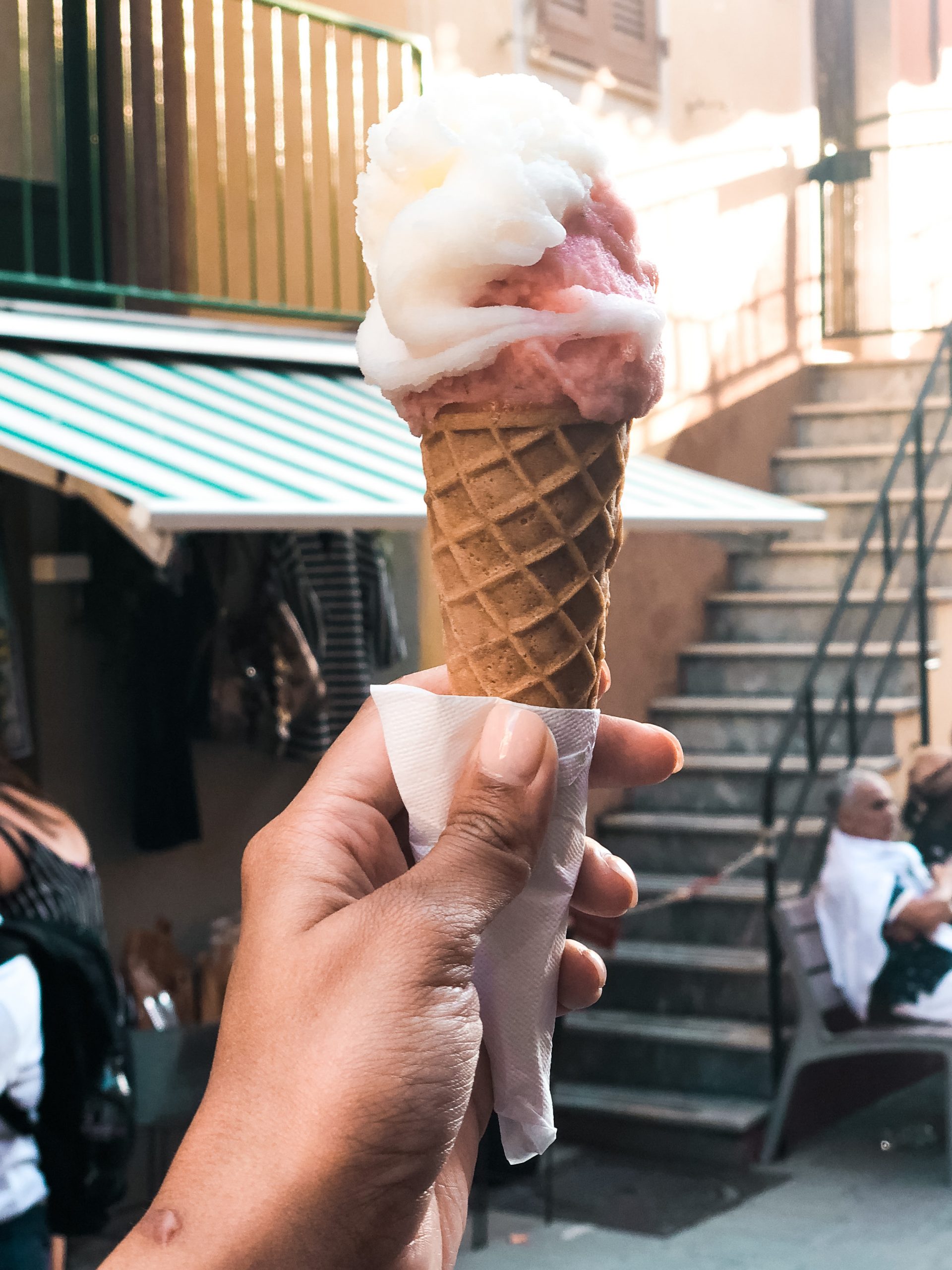 scoops of lemon and strawberry gelato on a cone