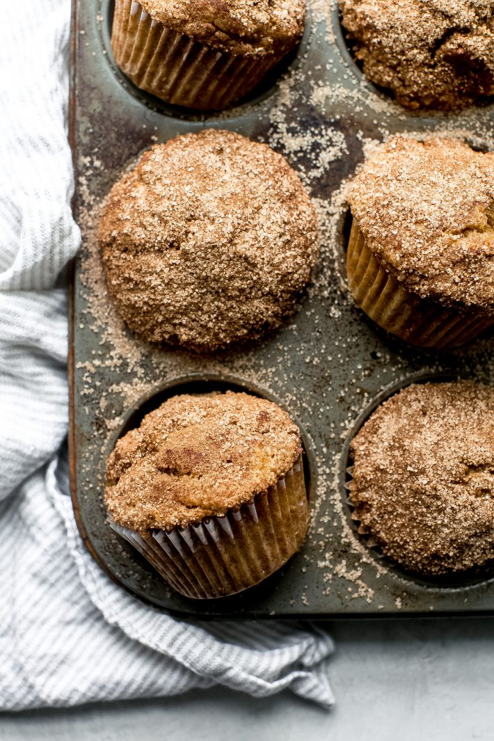 pumpkin snickerdoodle muffins in muffin pan with cinnamon sugar on top