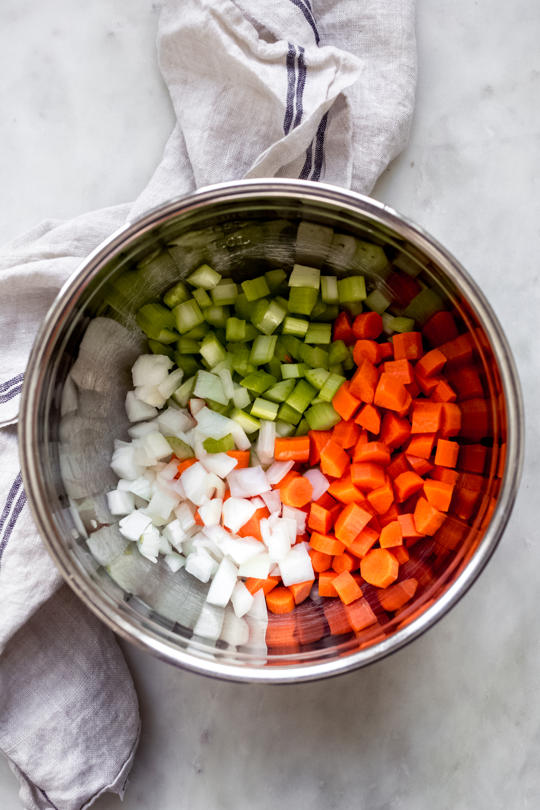 chopped onions, carrots, and celery in a stainless steel bowl