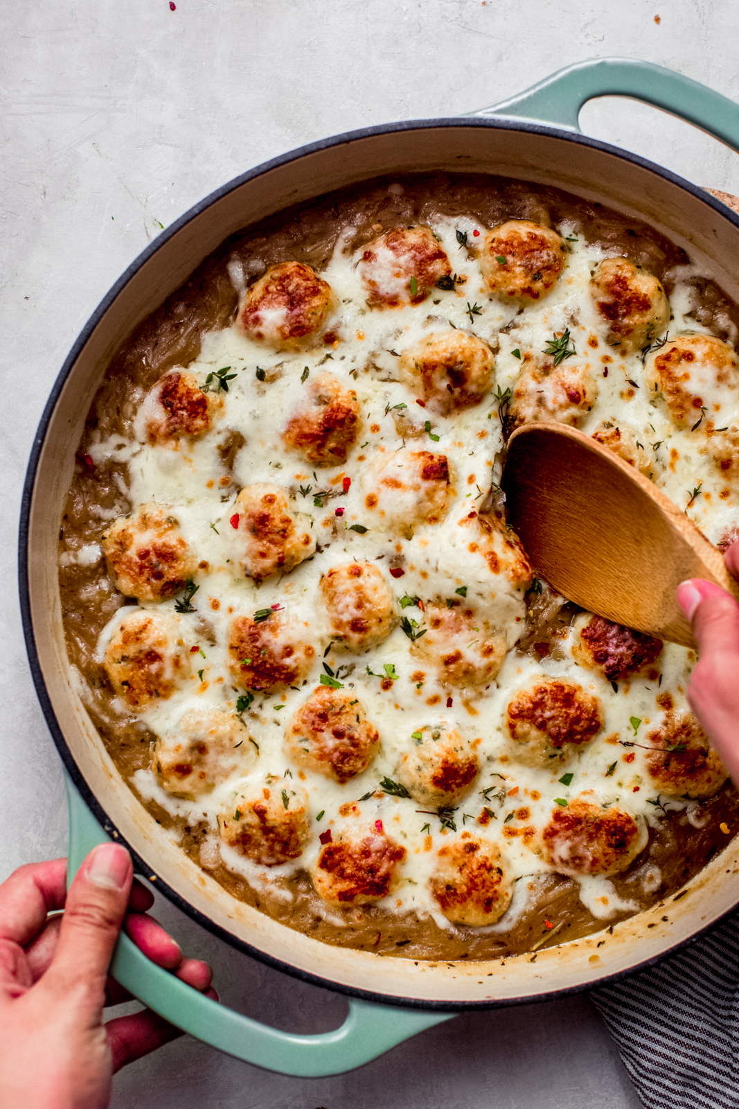 french onion chicken meatballs in cast iron dish with wooden spoon