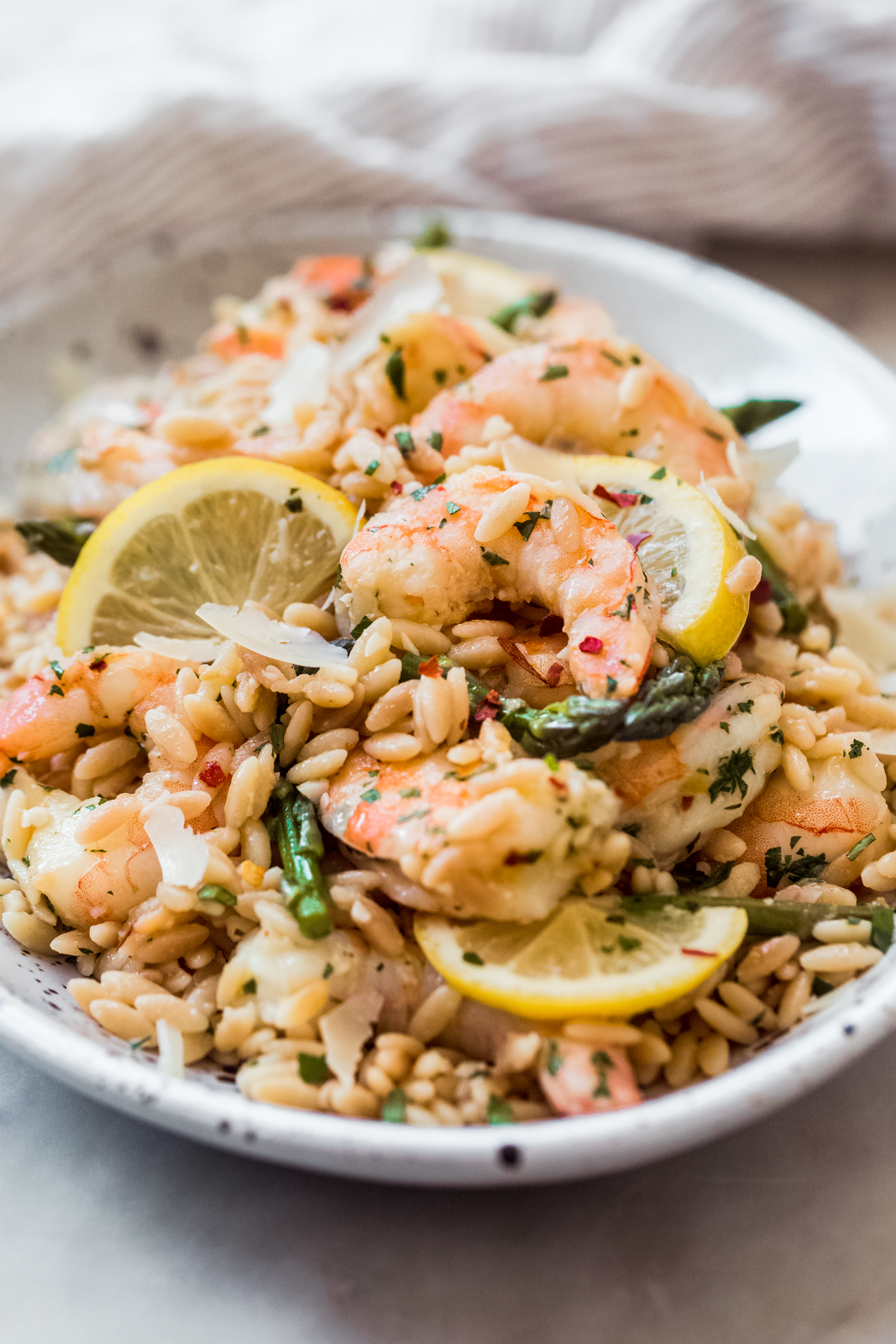 close up on shrimp on orzo on oval plate