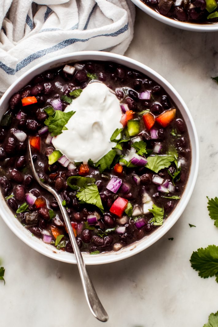 top shot of cuban black bean soup with dollop of sour cream