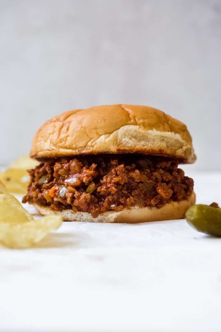 Close up for sloppy joes with chips and pickles