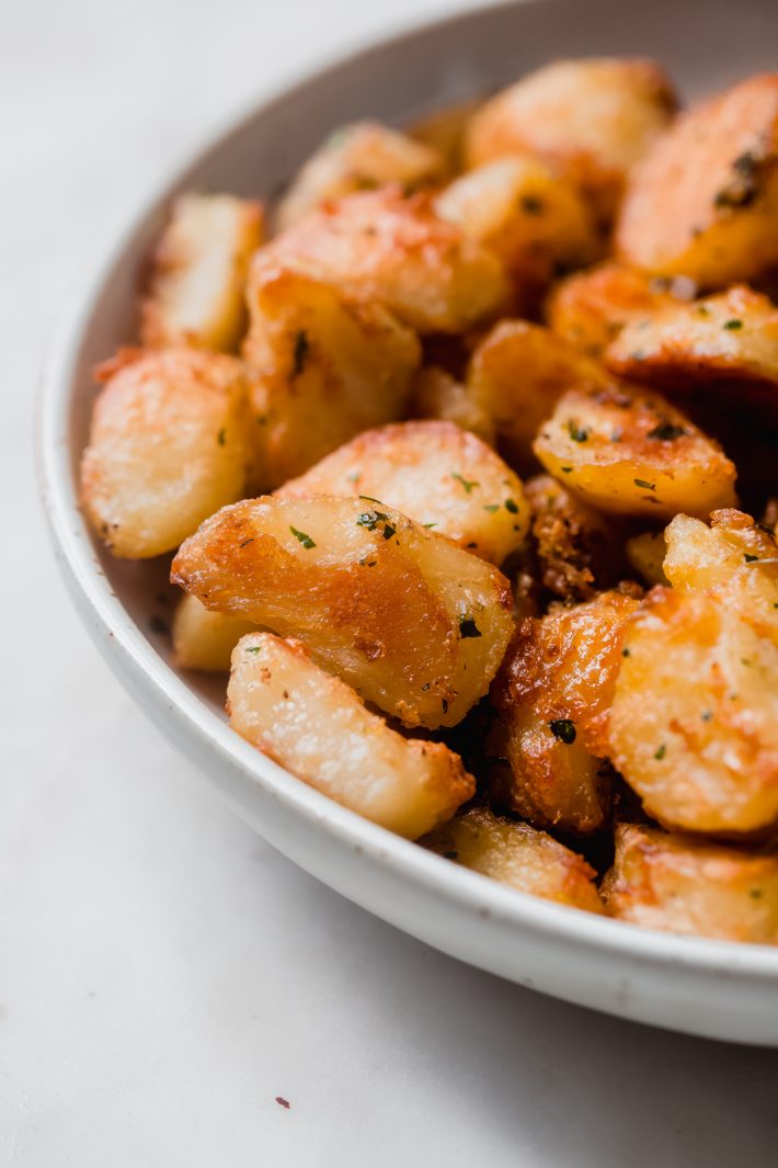 close up or crispy roasted potato texture in bowl