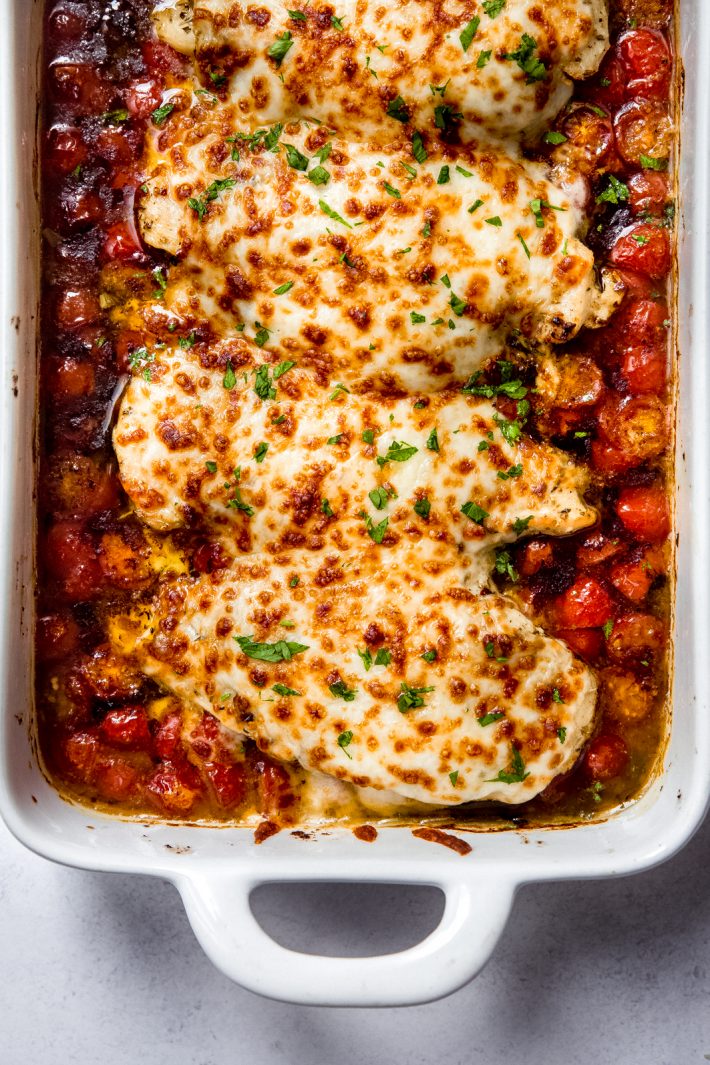 close up of one pan baked pesto chicken with tomatoes and mozzarella