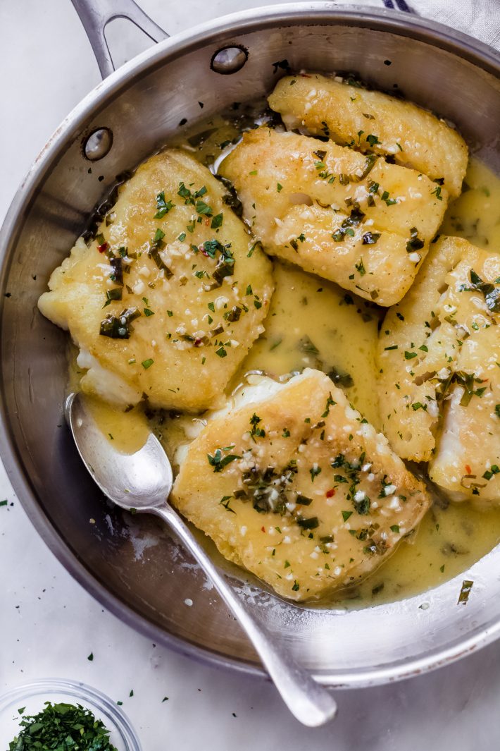 prepared fish with spoon in skillet