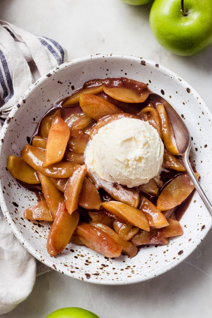 cinnamon apples in bowl with a scoop of vanilla ice cream