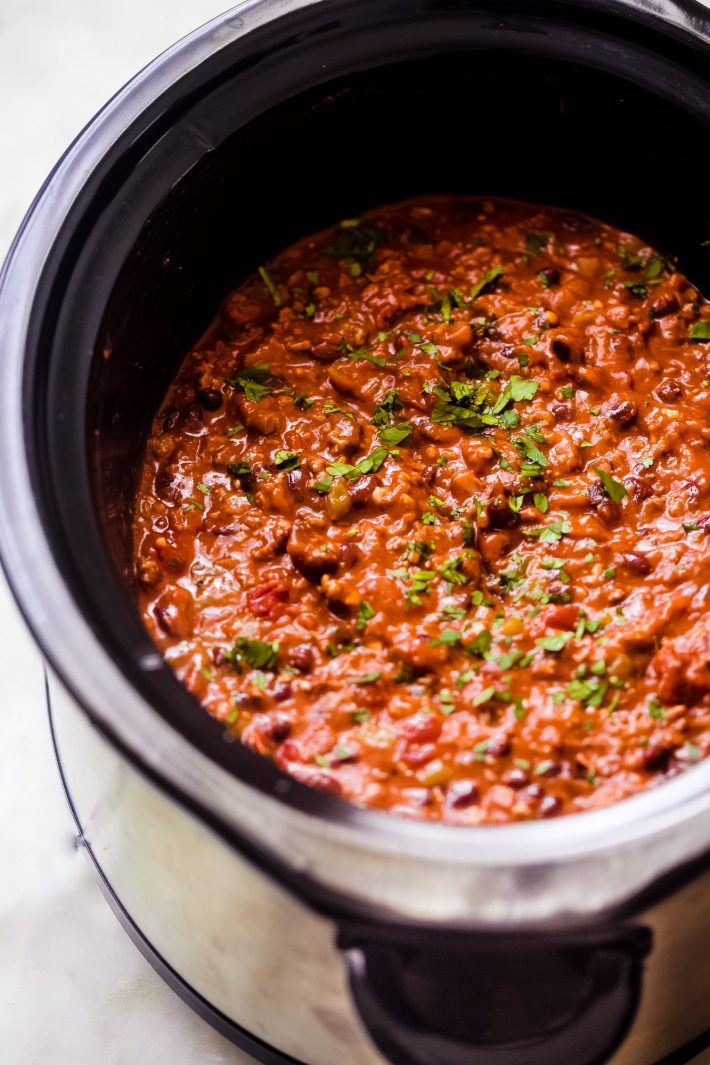 chili in slow cooker topped with cilantro